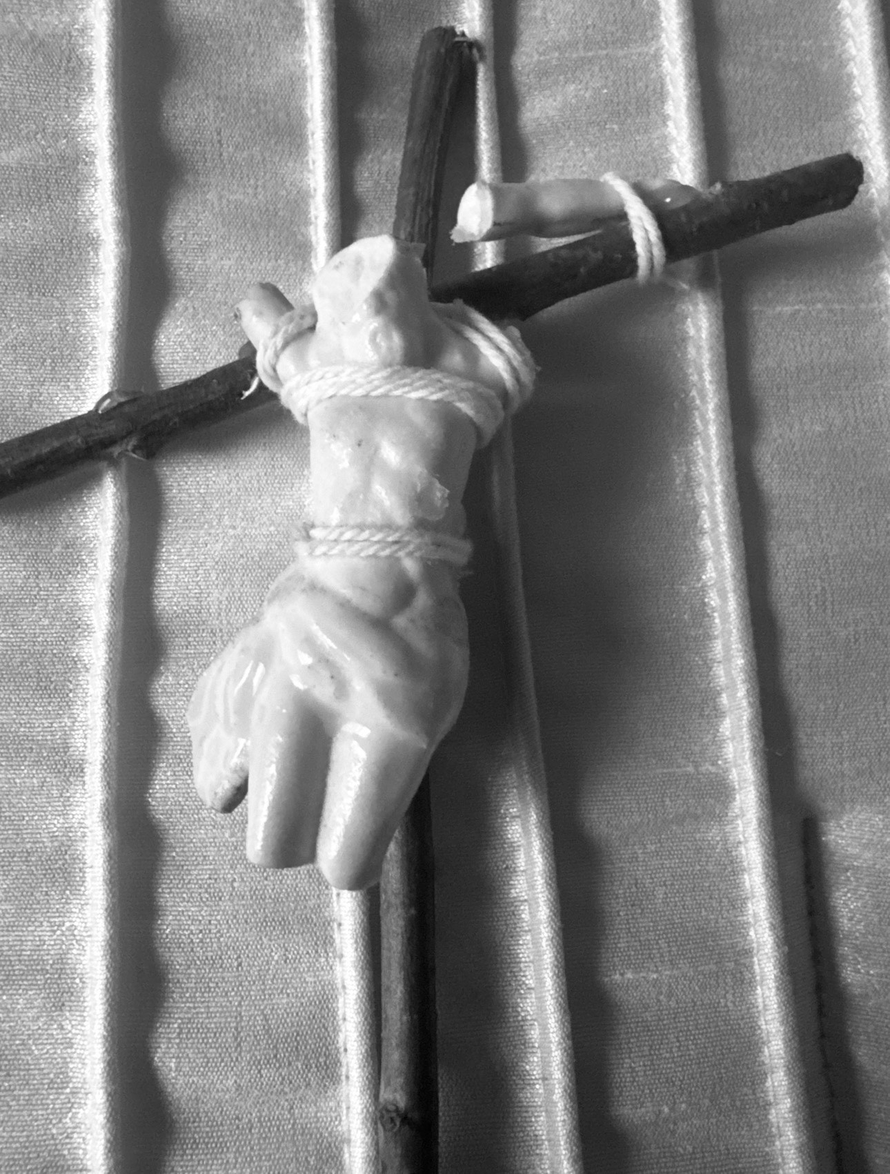 The actual broken porcelain corpus of Jesus tied with twine to the pine-stick cross Nicholas made