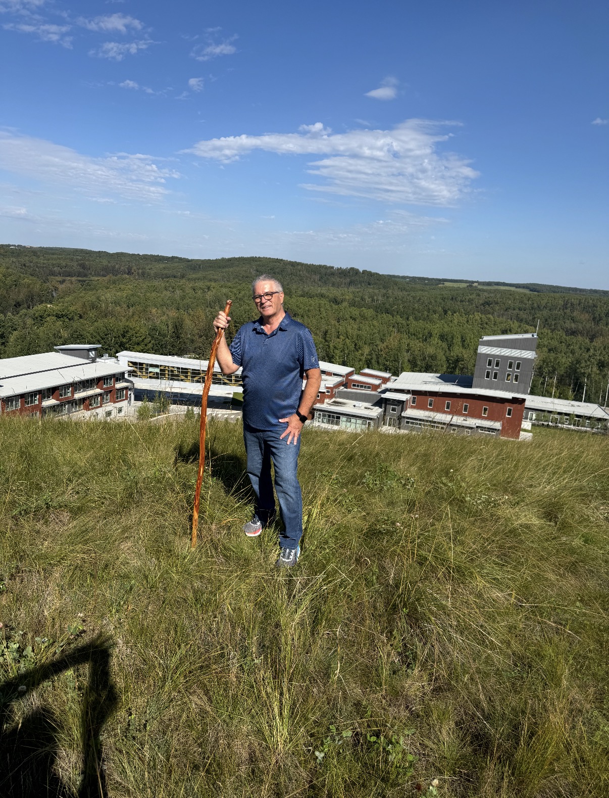 Richard Yancheski standing on the hill at Mount Carmel, with the centre buildings behind him
